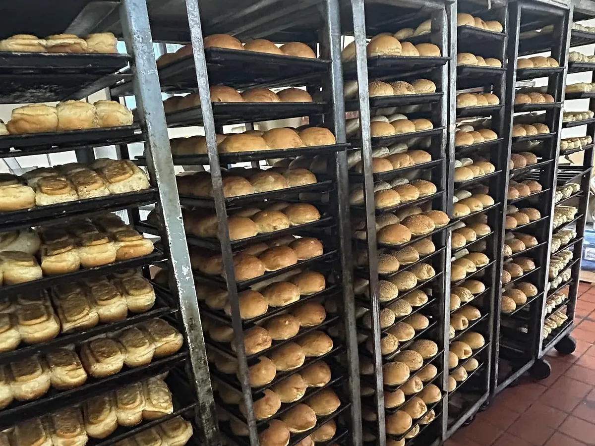 Tall racks of rolls on baking sheets in the bakery's kitchen